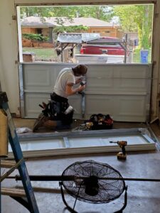 A technician installing a residential garage door panel for Garage Door Specialists Of Oklahoma Inc. in Midwest City, OK.