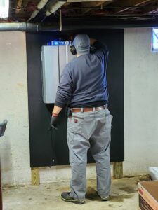 A technician installing a Rinnai tankless water heater for Derry Plumbing & Heating in Derry, NH.