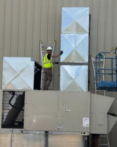 A technician installing rooftop ductwork for a commercial HVAC unit by Southern Comfort Heating & Cooling in Lexington, KY