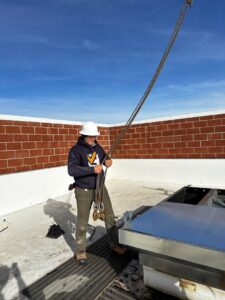A technician in a hard hat installing a rooftop HVAC unit for Boise Valley Heating & Air in Meridian, ID