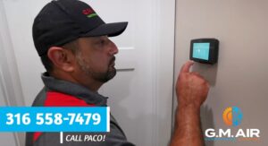 A technician installing or setting up a smart thermostat for G.M. AIR Conditioning & Heating in Wichita, KS.
