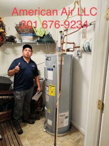 A technician from American Air LLC giving a thumbs up next to a newly installed water heater in Moncks Corner, SC