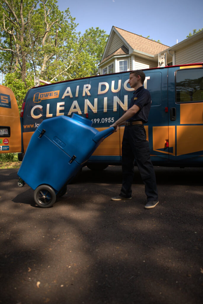 A technician monitoring the air duct cleaning process with specialized equipment at Lowe's Air Duct Cleaning in Fairlawn, OH.