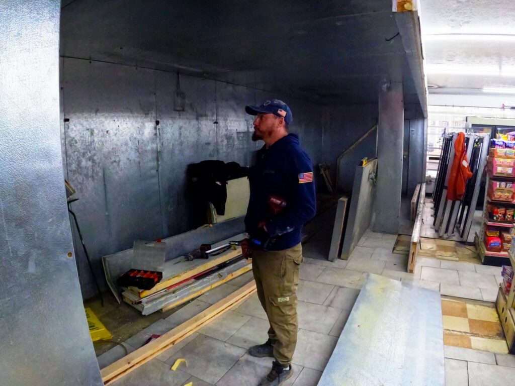 A technician from North East Ohio Master Plumbing, Heating, and Cooling Contractors on a job site holding a drill in Cleveland, OH.