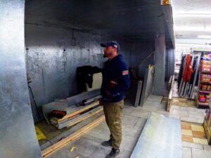 A technician from North East Ohio Master Plumbing, Heating, and Cooling Contractors on a job site holding a drill in Cleveland, OH.