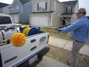 A Stomp Pest Control technician standing next to a service truck, ready for a pest control job in Raleigh, NC.