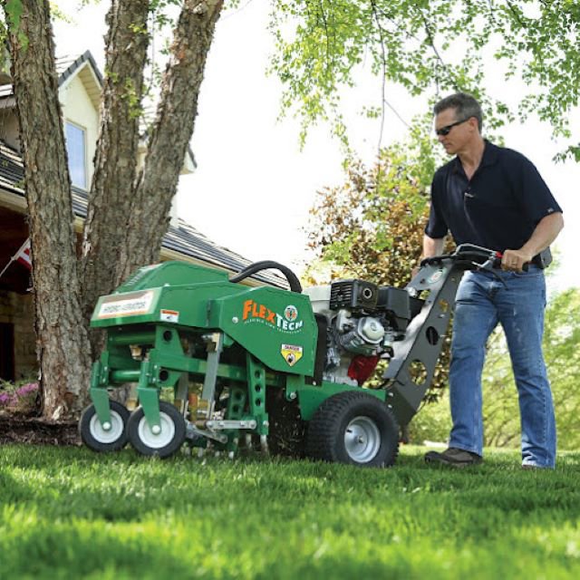 A technician operating a professional lawn aerator machine, providing turf care services by Nebraska Pro Turf & Pro Pest Solutions in Omaha, NE.