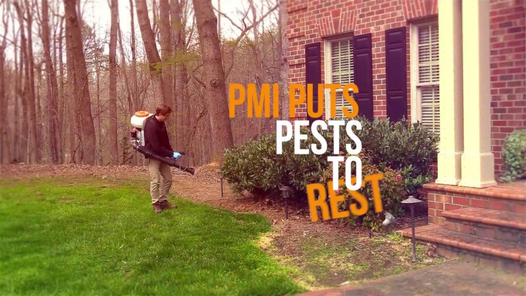 A Pest Management Systems, Inc. technician performing outdoor pest treatment on a residential lawn in Greensboro, NC