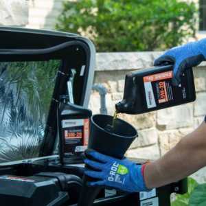 A technician performing an oil change on a Generac generator, pouring engine oil into the unit in Atlanta, GA.