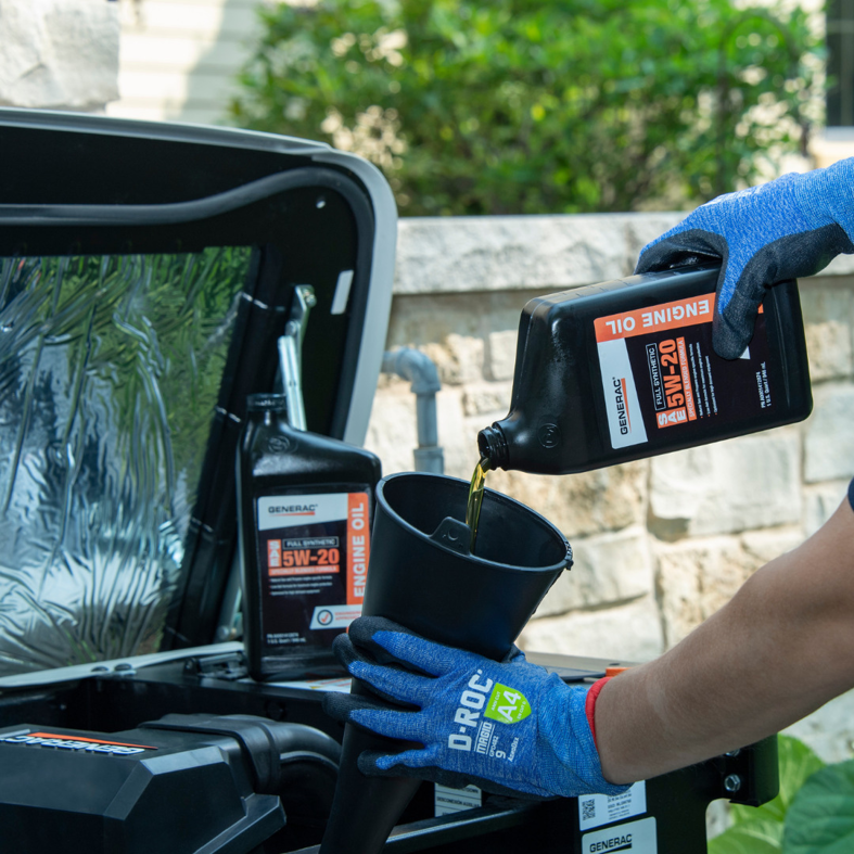 A technician performing an oil change on a Generac generator, pouring engine oil into the unit in Atlanta, GA.