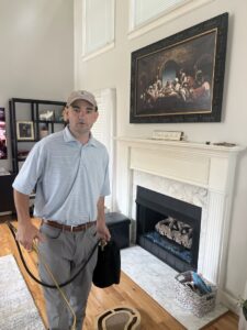 A technician from Athena Pest Control performing indoor pest control services near a fireplace in Birmingham, AL.