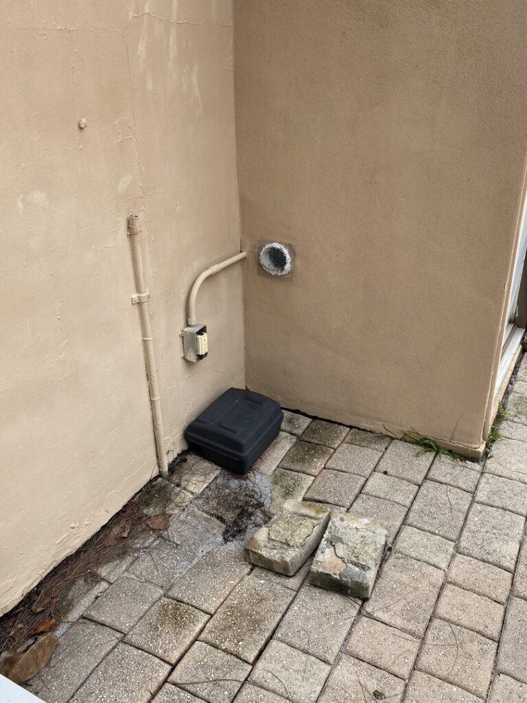 A Sure Shot Pest Solutions technician pointing towards wildlife near a trap during a control job in Fort Lauderdale, FL.