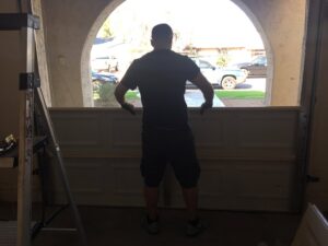 A technician positioning a garage door panel during installation by Nate's Garage Door Repair in Scottsdale, AZ.