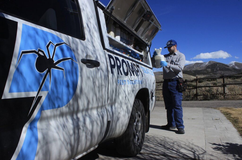 A Prompt Pest Solutions technician preparing pest control equipment from their truck in Pocatello, ID.