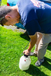 A pest control technician preparing a sprayer for pest treatment services at Advanced Pest Control Solutions in Youngstown, OH.