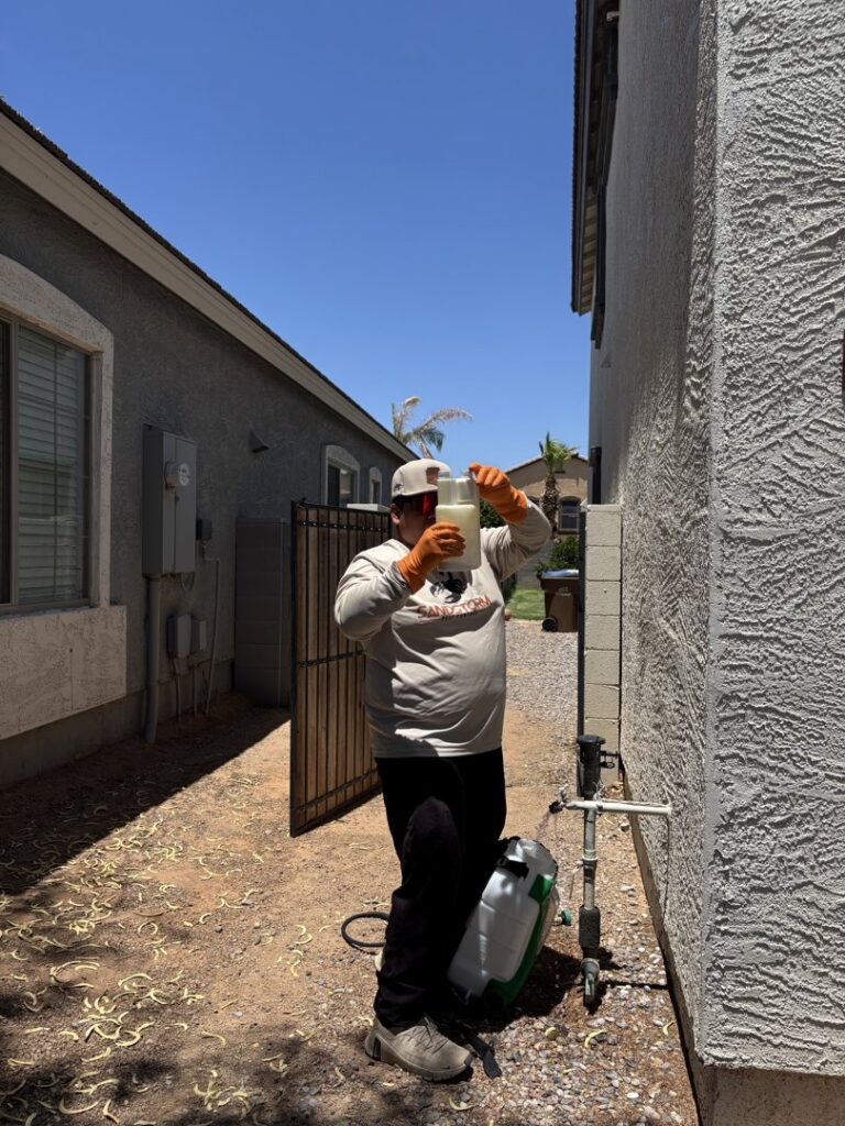 A pest control technician from Sandstorm Pest Control preparing a sprayer for treatment in Chandler, AZ.