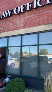 A technician from S&J Carpet Care pulling a cleaning hose into a law office for commercial carpet cleaning in Oswego, IL