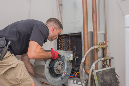 A technician removing a furnace blower motor during service for Daniels HVAC Philadelphia LLC in Philadelphia, PA.