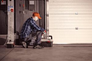 A technician repairing a commercial garage door, a service offered by Fort Wayne Door & Dock, Inc. in Fort Wayne, IN