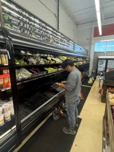 A technician repairing a commercial refrigeration display case in a grocery store for Setpoint Refrigeration LLC in Liberty Hill, TX