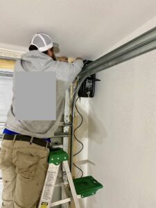 A technician repairing a garage door opener or track system for Specialty Garage Door in Bossier City, LA