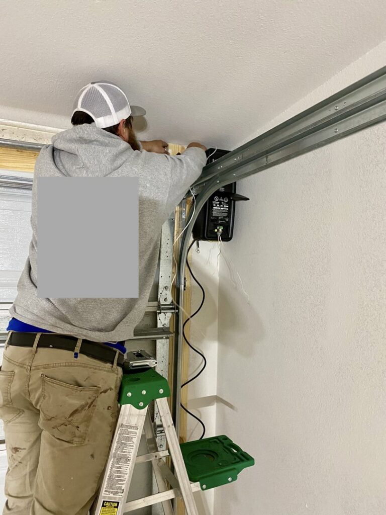 A technician repairing a garage door opener or track system for Specialty Garage Door in Bossier City, LA
