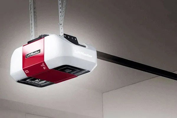 A technician on a ladder repairing a garage door opener, demonstrating service from Your Other Front Door LLC in Lakewood, CO.