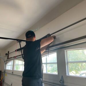 A technician repairing a garage door spring and track system for The Region's Garage Door Repair in Hammond, IN.