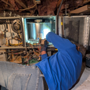 An HVAC technician performing repairs on an indoor unit at a client's home for Speedy Nelson HVAC Repair in Durham, NC.