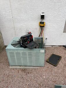 A Mountainside Air technician repairing an outdoor AC unit with tools in Phoenix, AZ.