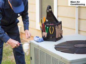 A technician repairing an outdoor HVAC condenser unit for Bijan Air-Conditioning in Chandler, AZ