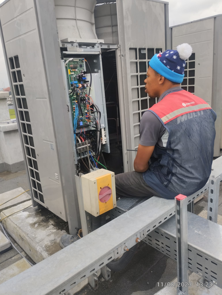 A Facilityfix technicians' HVAC contractor repairing an outdoor commercial HVAC unit in Port Harcourt, NG.