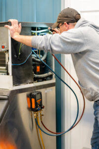 A Beman's Sales & Service technician replacing a furnace air filter in Hastings, NE.