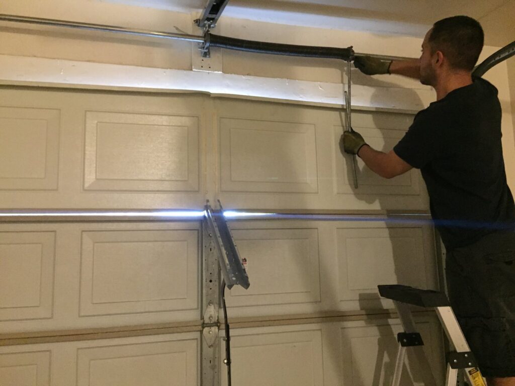 A technician replacing a garage door torsion spring for Nate's Garage Door Repair in Scottsdale, AZ.