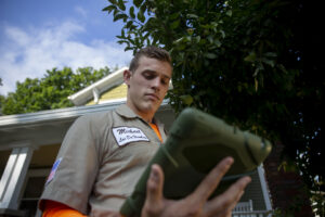 A Mosquito Hunters of Austin - Round Rock - Pflugerville technician reviewing a pest control plan on a tablet at a client's property in Austin, TX.