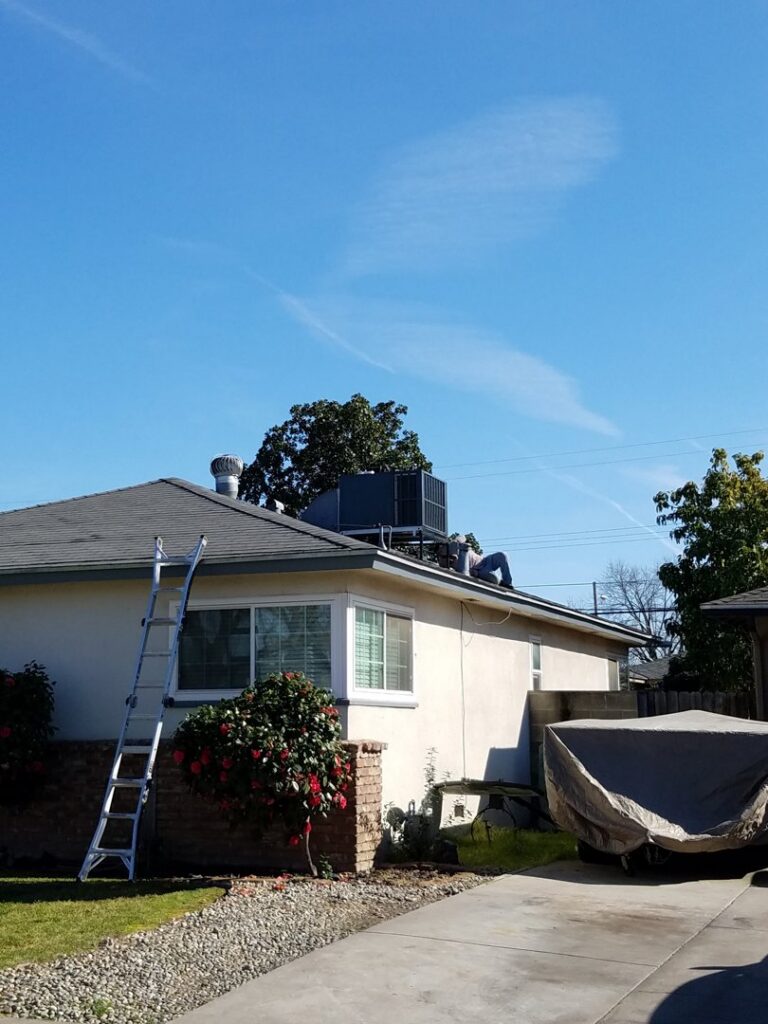 An HVAC technician on a roof performing service on a unit for All Pro Air in Warrenville, IL.