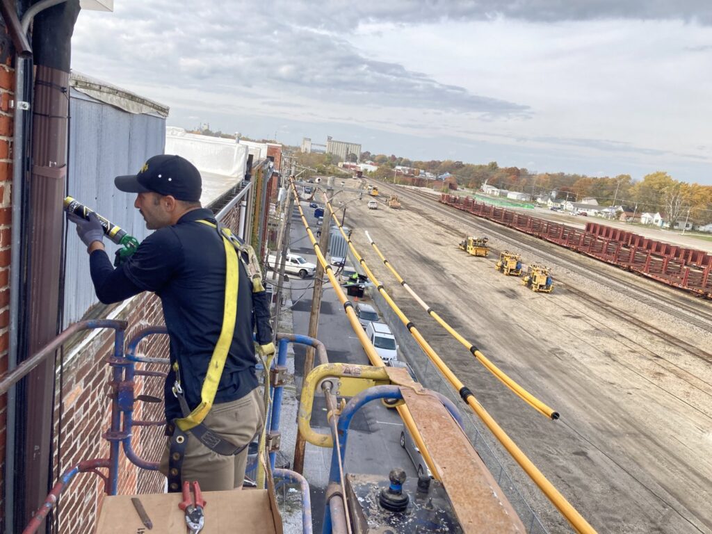 Critter Control technician sealing a commercial building exterior for pest exclusion in Springfield, MO