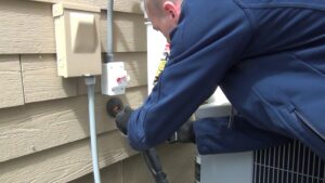 A technician sealing a pipe entry point on the exterior of a house for pest exclusion by Springer Professional Home Services in Des Moines, IA.