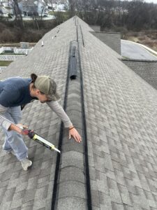 A technician sealing a roof ridge vent with mesh for wildlife exclusion and prevention by Elite Wildlife Removal and Prevention in Nashville, TN.