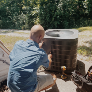 A technician from Davis Heating, Air Conditioning & Home servicing an outdoor AC unit in Overland Park, KS.