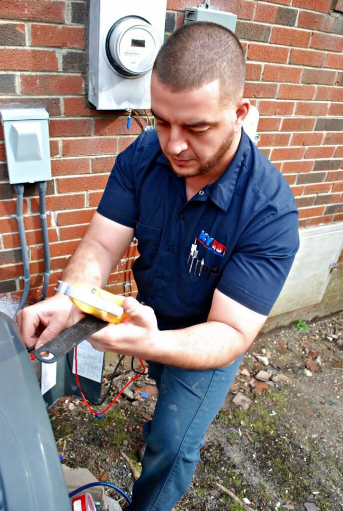 An Icy Hot Heating and Air Conditioning technician servicing an outdoor AC unit in Raleigh, NC.