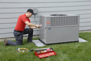 A technician from Kelly Heating & Electric, LLC servicing an outdoor air conditioning unit in Eau Claire, WI.