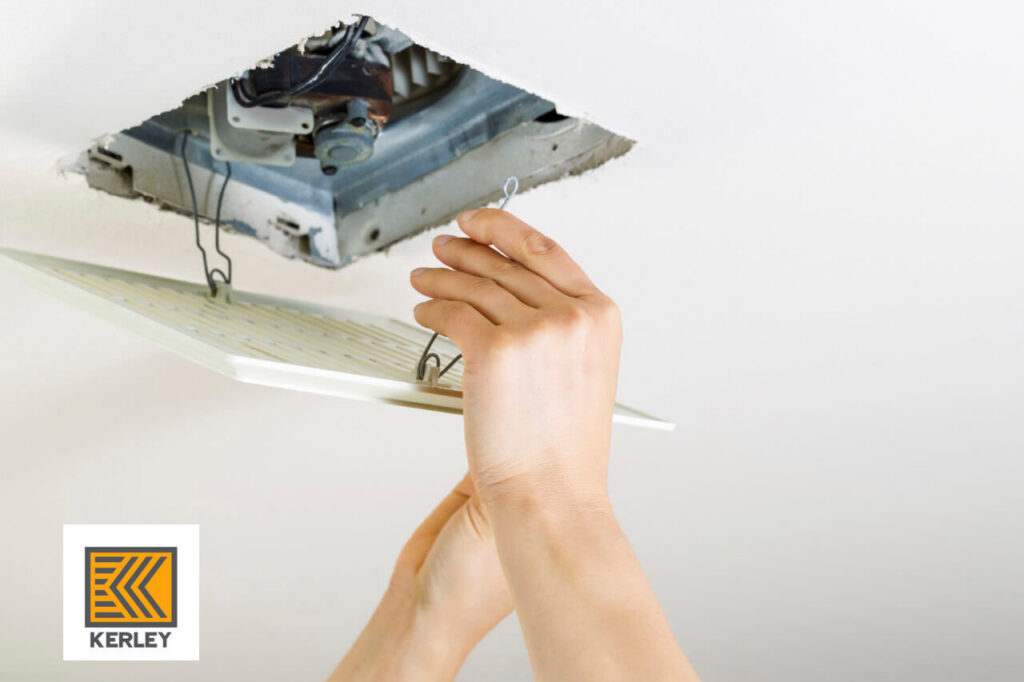 A technician's hands servicing a ceiling ventilation fan, demonstrating HVAC maintenance by Kerley Heating & Cooling in Rock City, IL