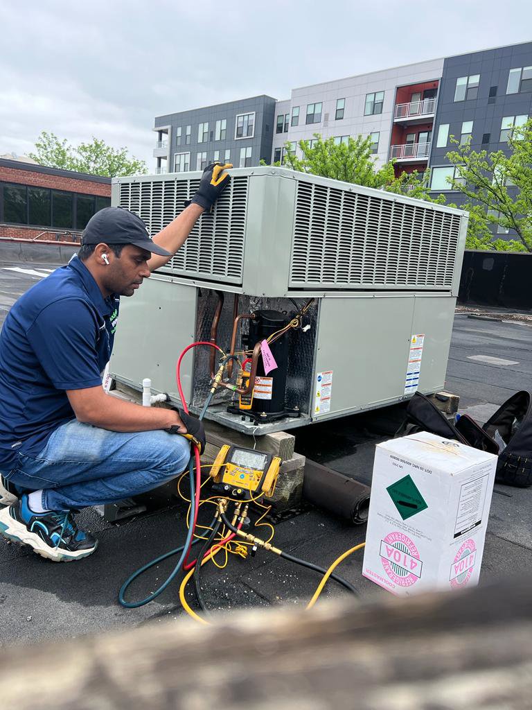 A technician servicing a commercial rooftop HVAC unit with gauges for Modern HVAC Technology in Chicago, IL.