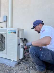 An Instant Air technician servicing an outdoor Daikin mini-split condenser unit in Las Vegas, NV.