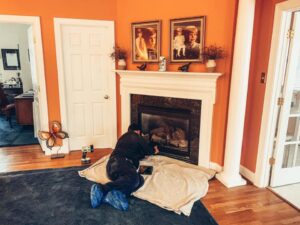 A technician servicing a fireplace insert at a home for Rooftop Chimney Sweeps in Alexandria, VA.
