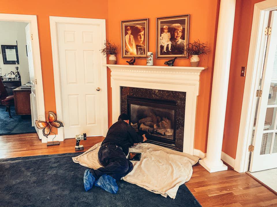 A technician servicing a fireplace insert at a home for Rooftop Chimney Sweeps in Alexandria, VA.