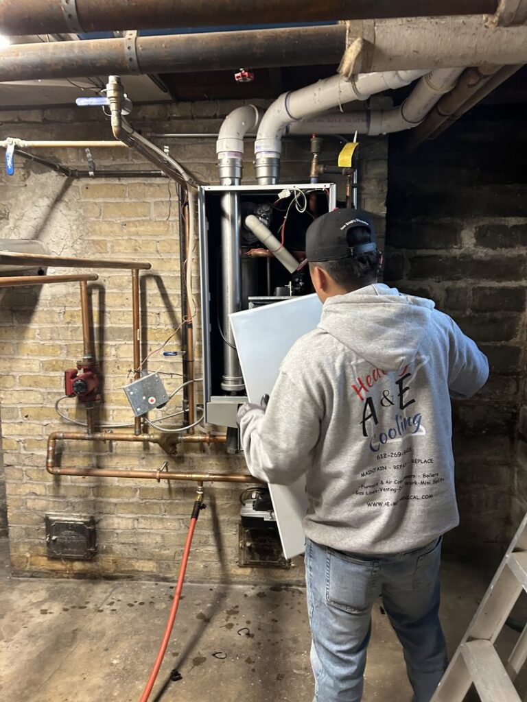 An A&E Heating & Cooling technician servicing an indoor furnace unit in Fort Worth, TX.
