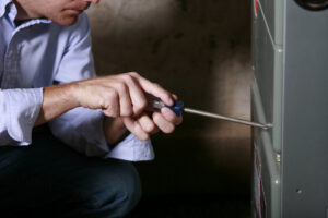 A technician servicing a furnace unit at Bennett Furnace Cleaning in East Peoria, IL.