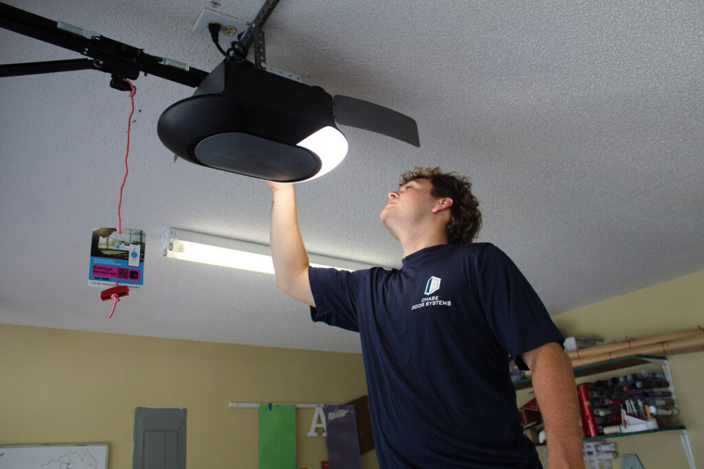 A Chase Door Systems technician servicing a garage door opener in Summerville, SC.